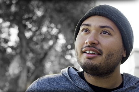 image of a man smiling, wearing a cap